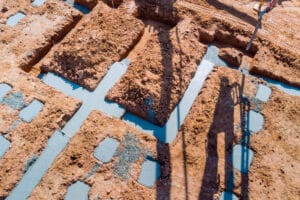 When constructing house foundations are poured using an automatic pump to direct cement concrete into the concrete strip foundations.